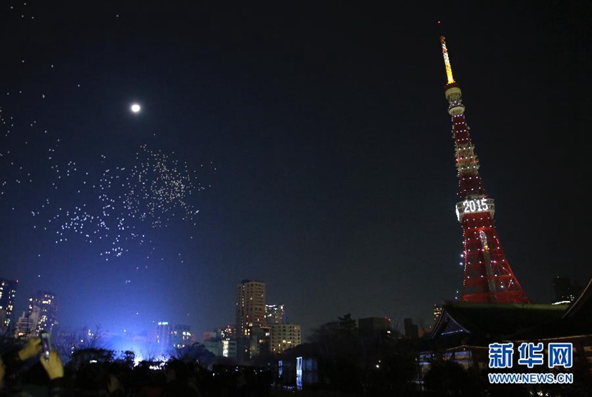 1月1日，日本東京鐵塔亮起燈光，慶祝2015年的到來。新年是日本重要的節日之一。除觀看煙花表演和參加篝火晚會外，許多日本民眾還會前往附近寺廟，祈求健康和快樂。