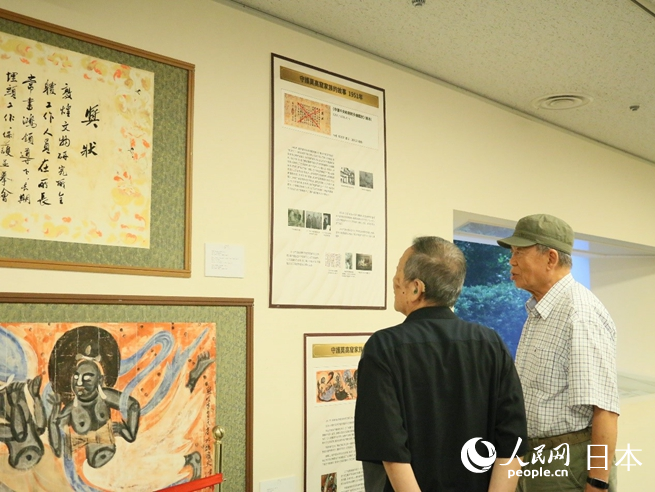 日本絲綢之路藝術協會會長常嘉煌（右一）向日本民眾介紹展出作品。人民網 許可攝