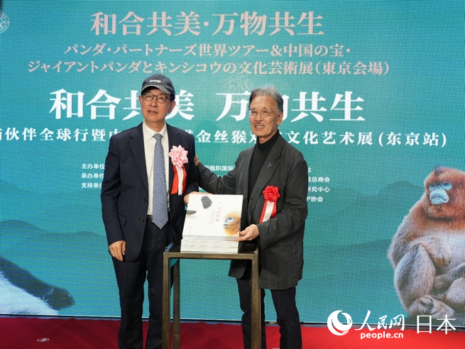 薛康（左）与土居利光（右）为《中国双宝：享誉世界的大熊猫和金丝猴》摄影画册发布揭幕。人民网 许可摄
