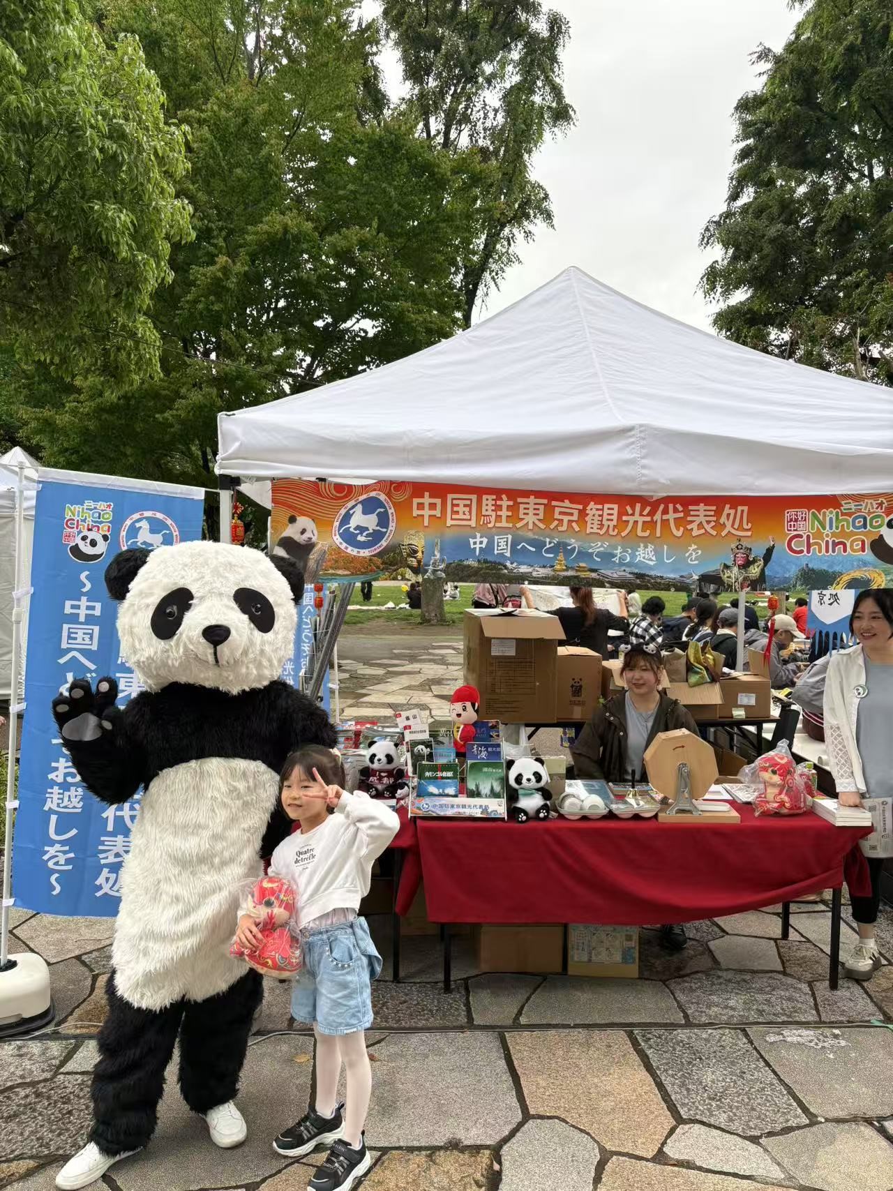 到场民众与大熊猫人偶合影。中国驻东京旅游办事处供图