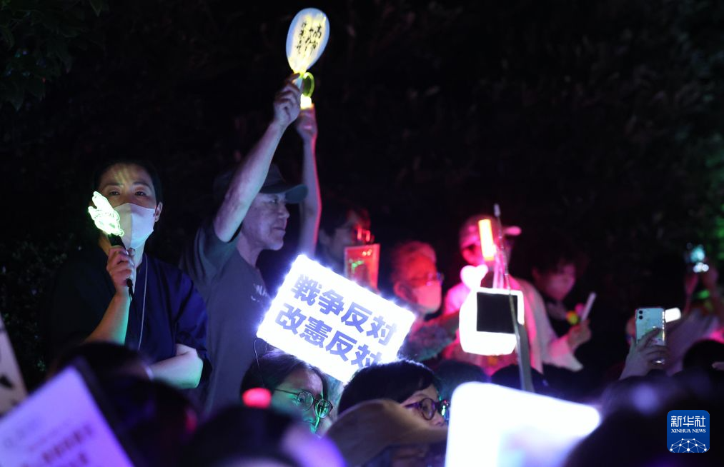 7月10日，在位于日本东京的国会议事堂前，民众手持标语参加抗议集会。新华社记者 岳晨星 摄