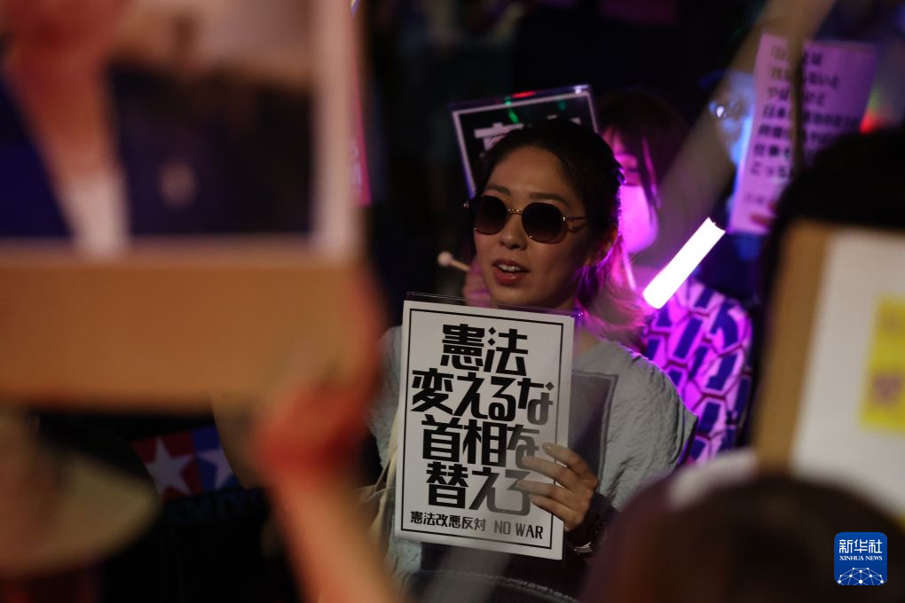7月10日，在位于日本东京的国会议事堂前，民众手持标语参加抗议集会。新华社记者 岳晨星 摄