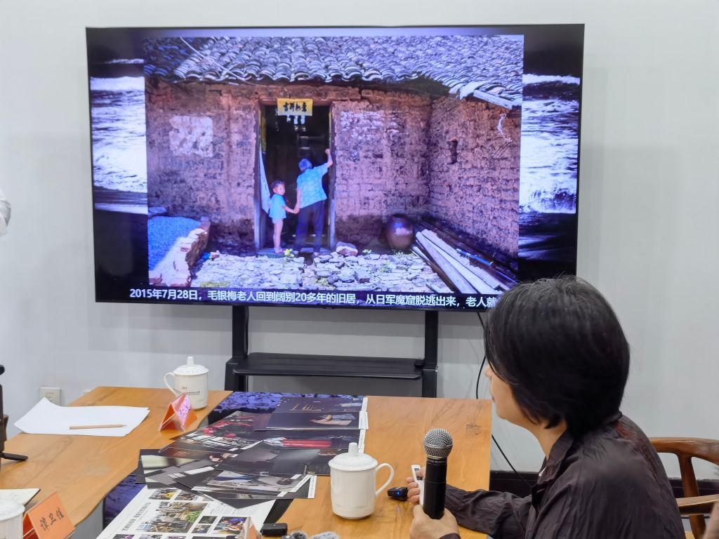 8月14日，晏美華介紹自己拍攝的韓裔日軍“慰安婦”制度受害幸存者毛銀梅的照片。新華社記者 邱冰清 攝