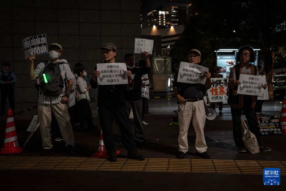 10月14日，民众手持标语在位于日本东京的美国驻日本大使馆外参加抗议活动。新华社记者 贾浩成 摄