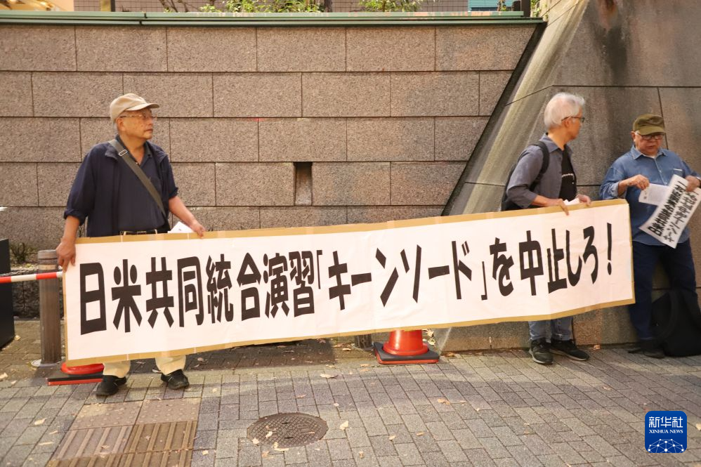 10月20日，在日本东京，抗议者手持横幅抗议。新华社记者 李子越 摄