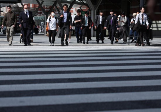 5月15日,在日本東京,行人通過東京站附近的一處人行橫道。新華社記者賈浩成攝