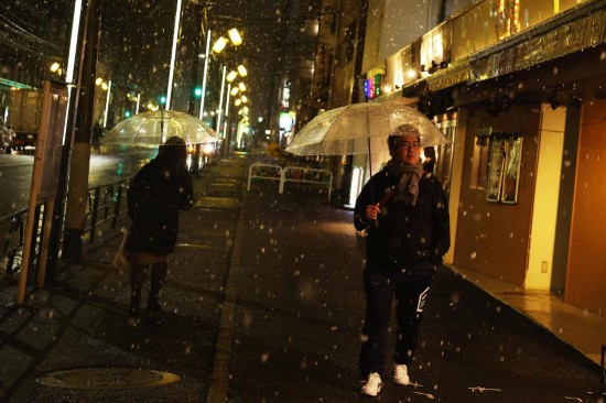 1月2日，行人撐傘走在日本東京街頭。當日，受冷空氣影響，日本東京降下2026年第一場雪。新華社記者賈浩成攝